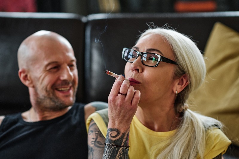 woman smoking weed with bald man